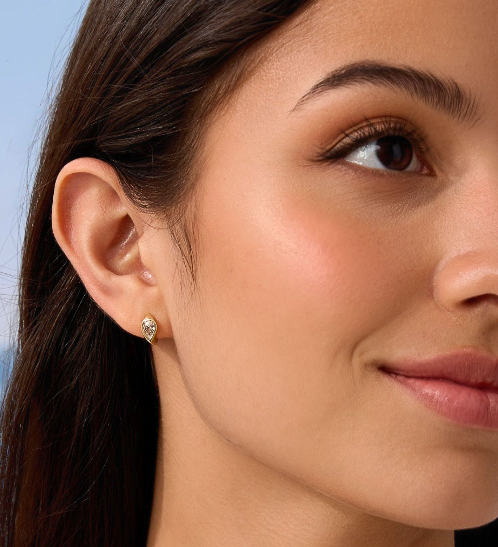 Close-up of a woman wearing a diamond earring with a blurred background