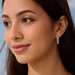 Close-up of a woman wearing a diamond earring with a blurred natural background