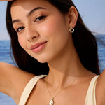 Woman wearing gold jewelry with a blue sky background