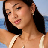 Woman wearing gold jewelry with a blue sky background